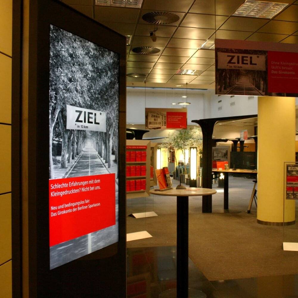 Digitale Stele als Werbestele & Digitales Schaufenster mit einem leuchtstarken 43 Zoll Display in einer Sparkasse.