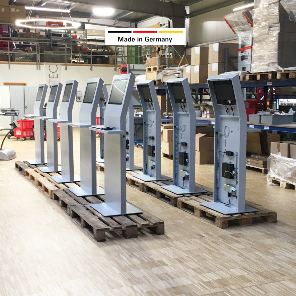 Acht fertig montierte Werkstation-Stelen mit Touch-Displays stehen auf Paletten in der Fertigung in Besigheim, bereit zur Auslieferung.