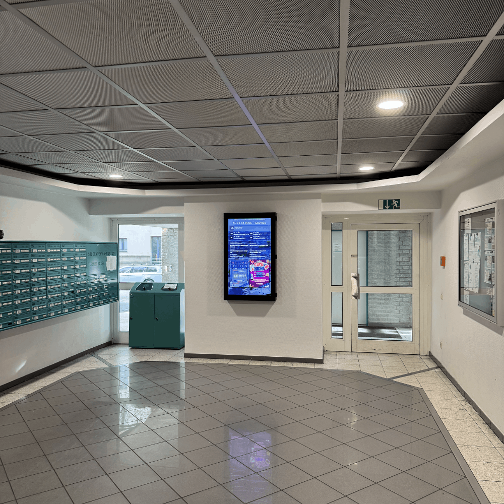 Robuste Einhausung für eine Digitale Haustafel DANI FP Pro mit Brandschutz – ideal für Flure in großen Wohnanlagen.